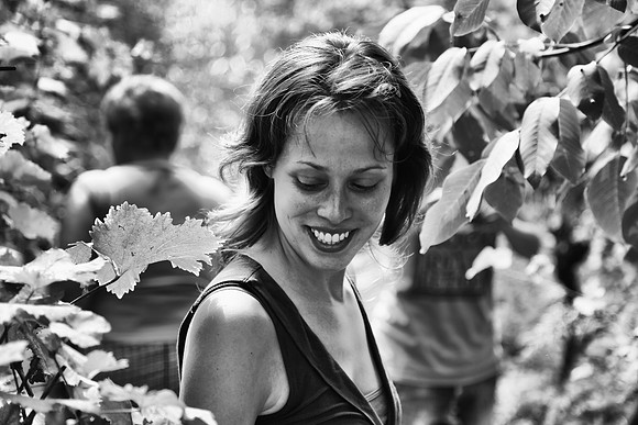 A woman stands in a vineyard
