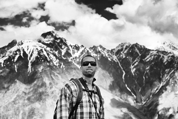 A man stands in Kazbegi with the Caucasus Mountains in the background
