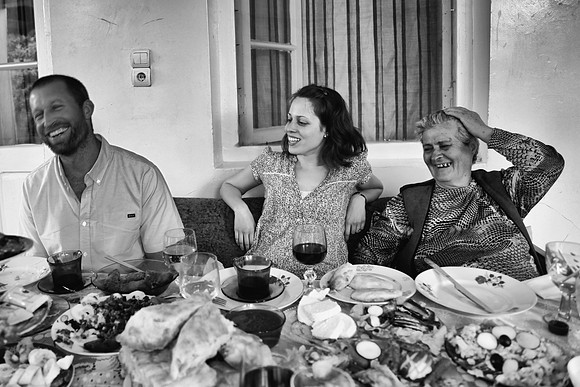 Friends and family sit and eat and laugh in Georgia